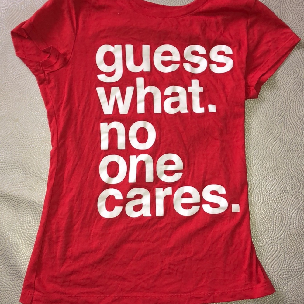 Large red shirt titled “guess what no one cares”